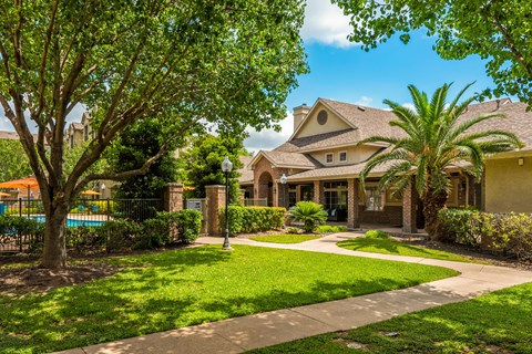 the front of a house with a yard and a swimming pool