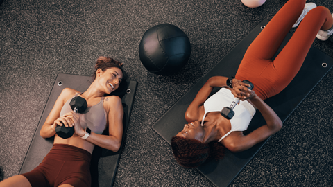 Two women exercising in a gym.