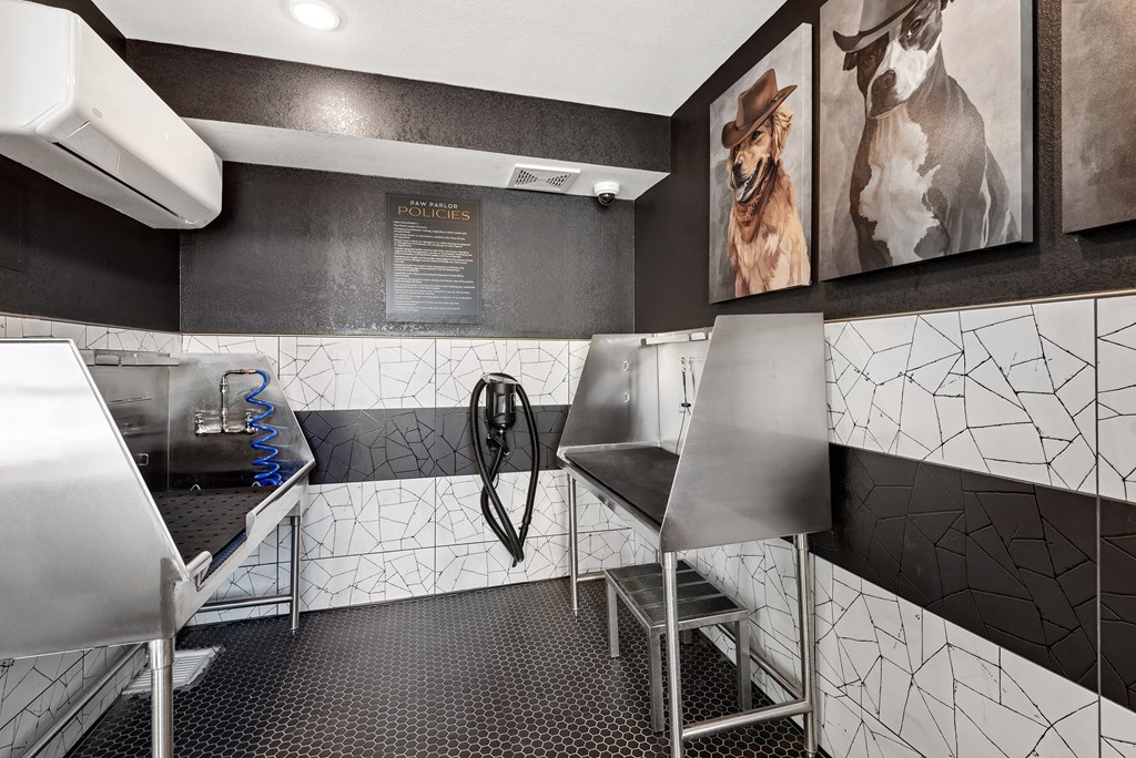 A modern bathroom with a black and white tiled wall and a shower area.