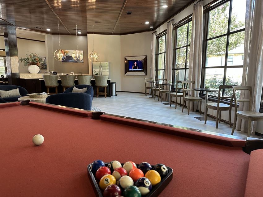 a pool table and bar in the clubhouse at the preserve at great pond apartments in windsor