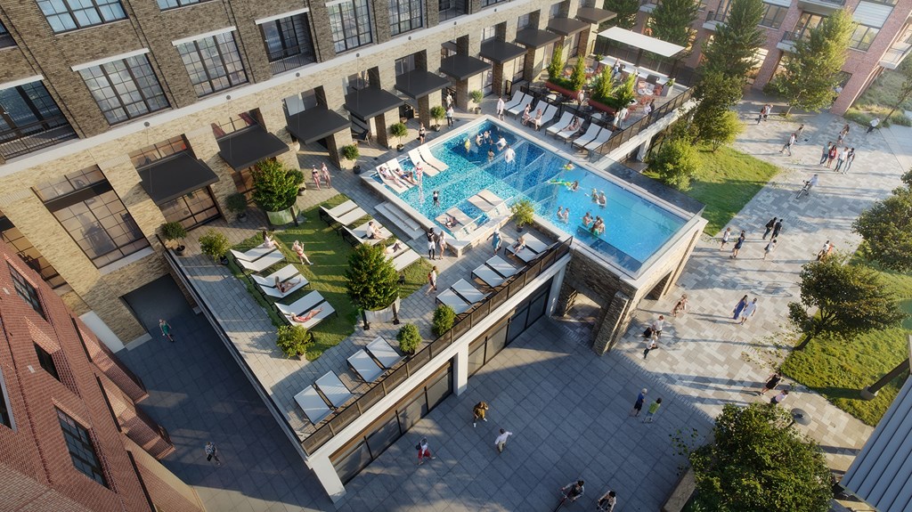 A large outdoor swimming pool surrounded by lounge chairs and umbrellas.