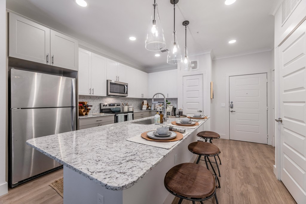 an open kitchen with marble counter tops and stainless steel appliances