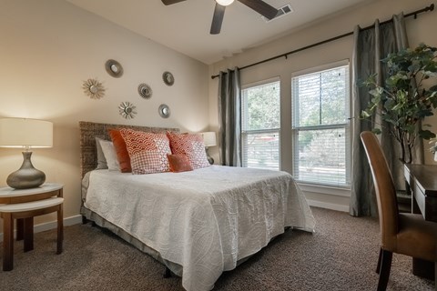 a bedroom with a bed and a desk with a chair