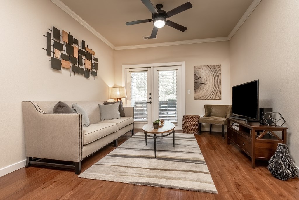 a living room with hardwood floors and a ceiling fan