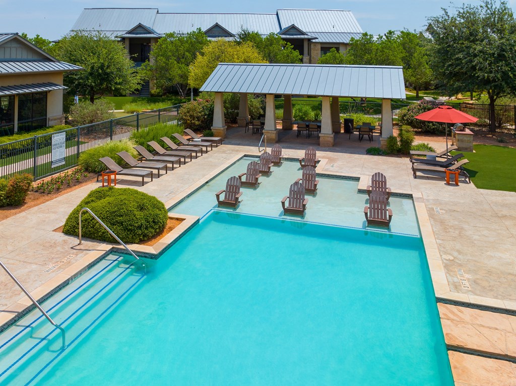 a swimming pool with lounge chairs and umbrellas