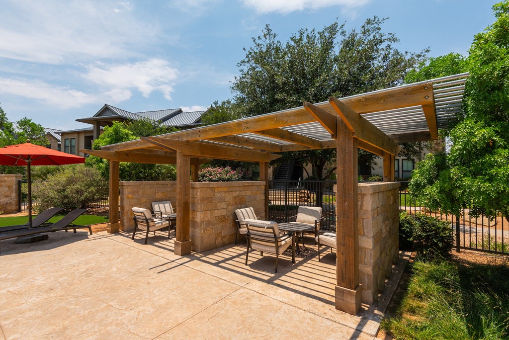 a patio with a pergola and patio furniture