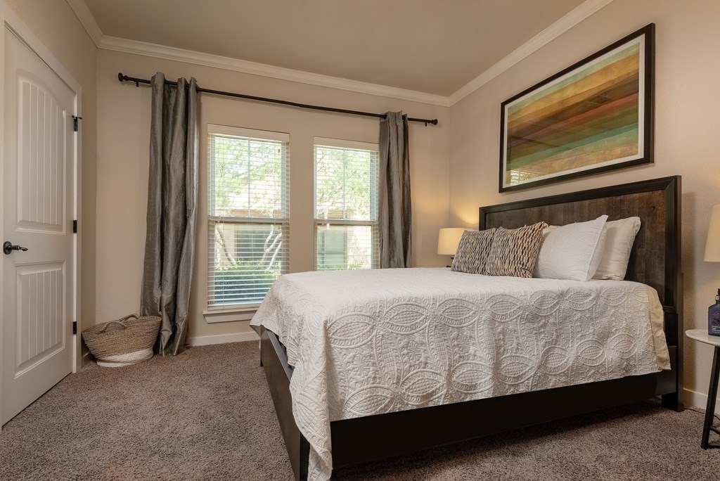 a bedroom with a bed and two windows