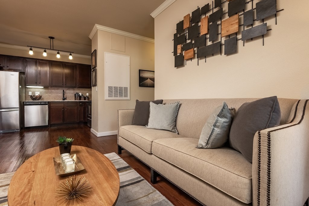 a living room with a couch table and a kitchen in the background