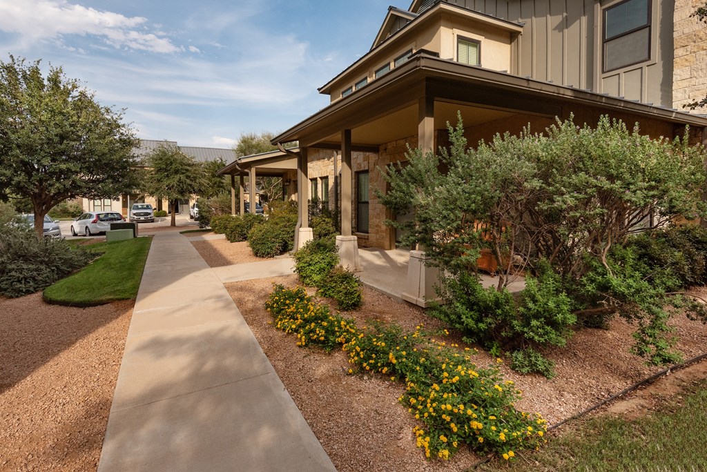 a home with a sidewalk and landscaping in front of it