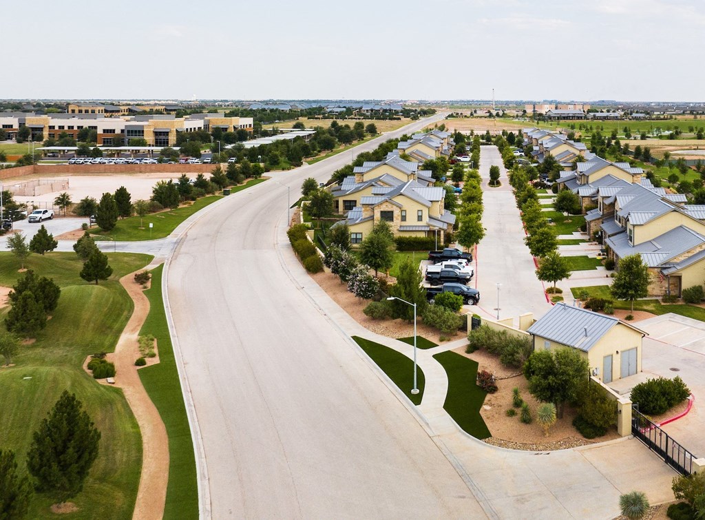an aerial view of a neighborhood with houses and a road