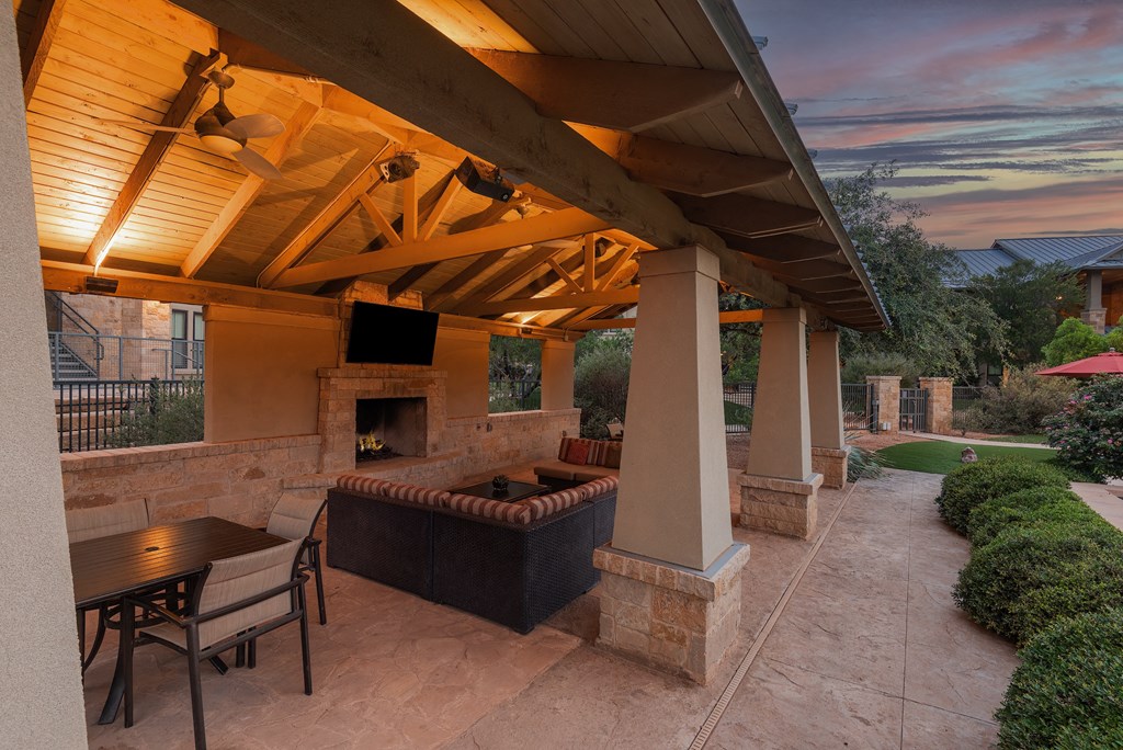 a covered patio with a fireplace and a tv
