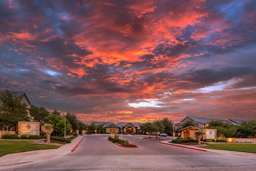 a street with houses and a sunset in the background