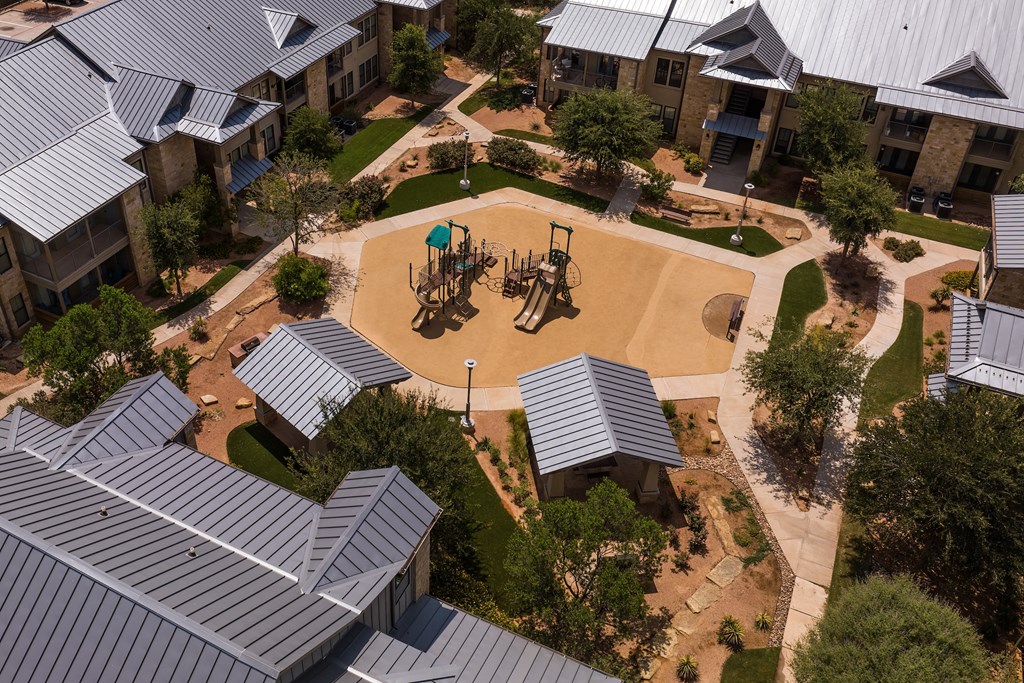 an aerial view of a playground in the courtyard of an apartment complex