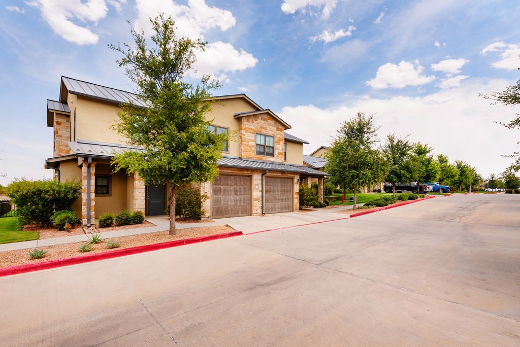 a house with a long driveway and a tree in front of it