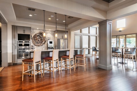a large kitchen with a bar and a dining area with chairs