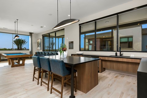A modern kitchen with a pool table and bar area.