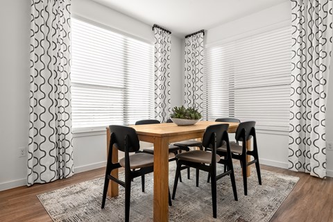 A dining room with a table and chairs.