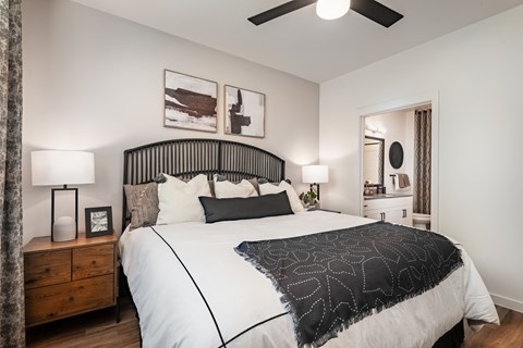 A bedroom with a large bed and a ceiling fan.