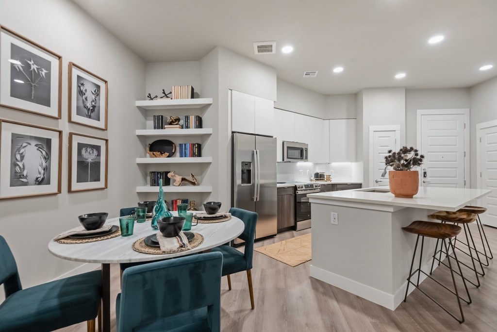 A modern kitchen with a dining table set for two.