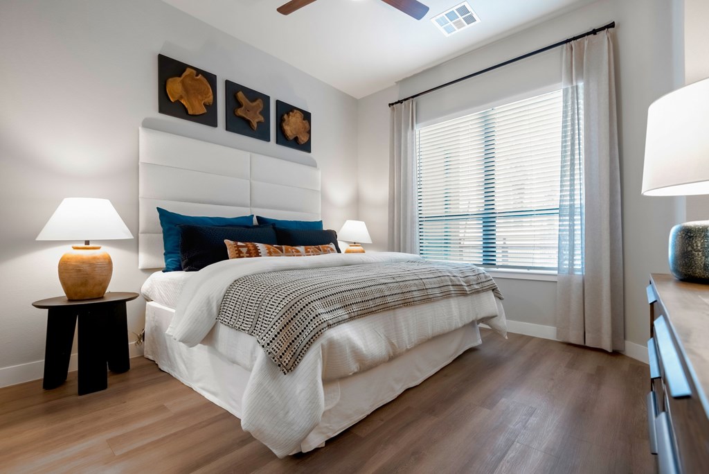 A bedroom with a large bed and a ceiling fan.