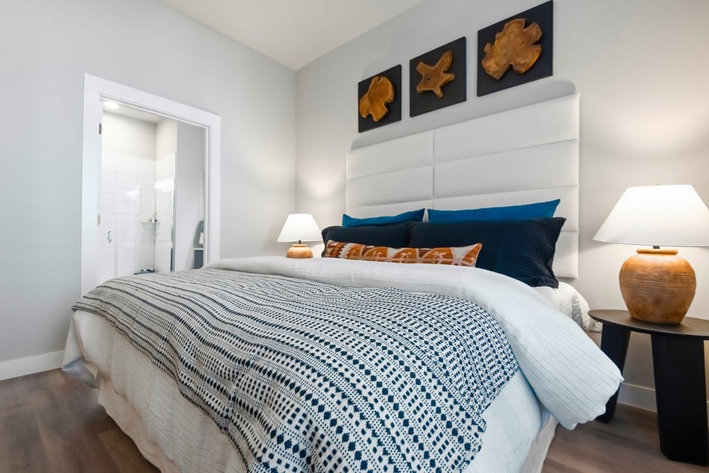 A bedroom with a bed covered in a blue and white blanket.