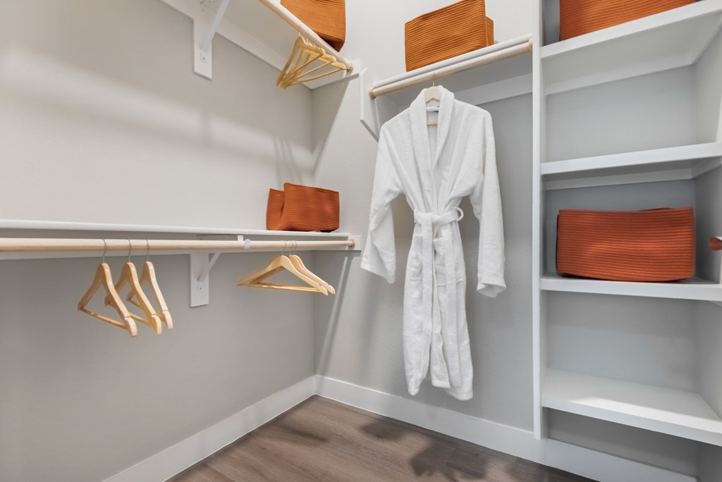 A white robe is hanging on a rack in a room.