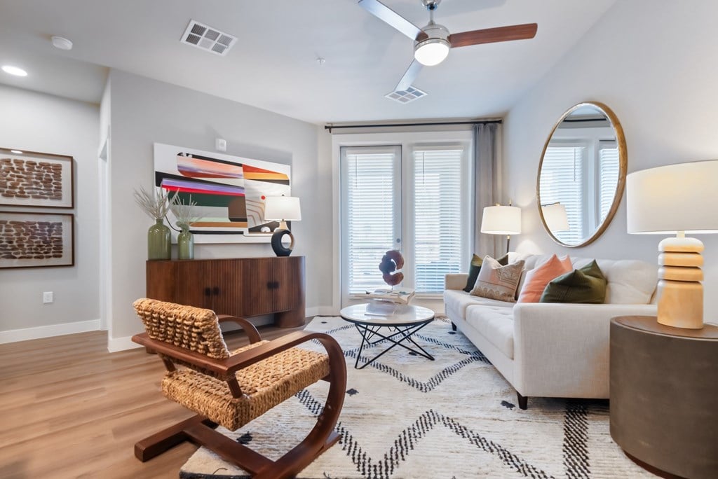 A living room with a white couch, a wooden chair, and a coffee table.