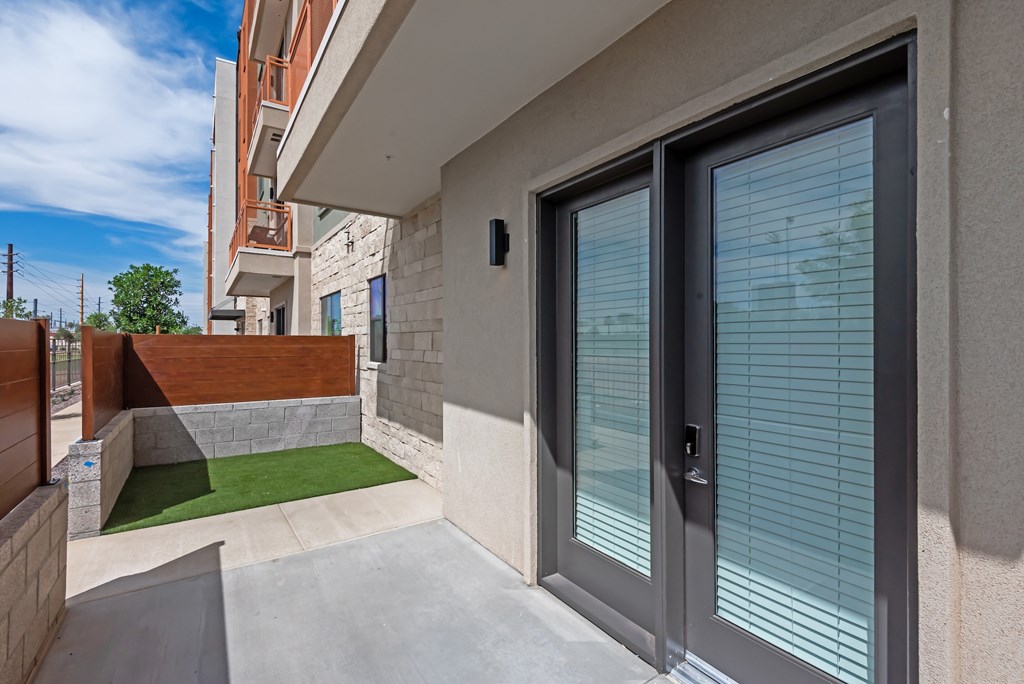 A modern house with a glass door and a small garden.