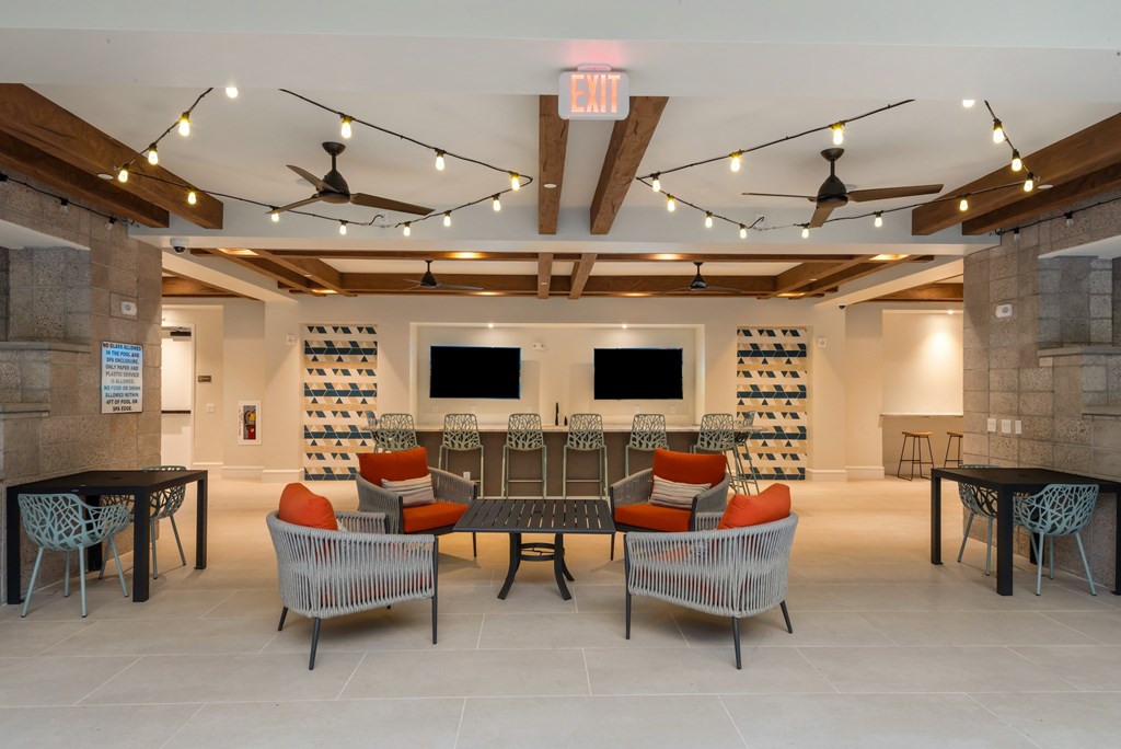A room with a long table and chairs with a TV on the wall.