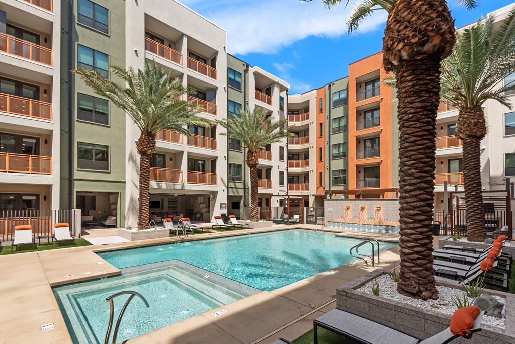 A pool surrounded by palm trees and chairs.