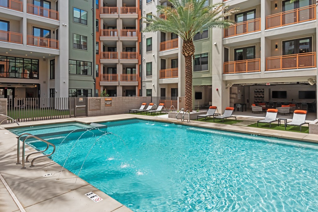 A large swimming pool in front of apartment buildings.