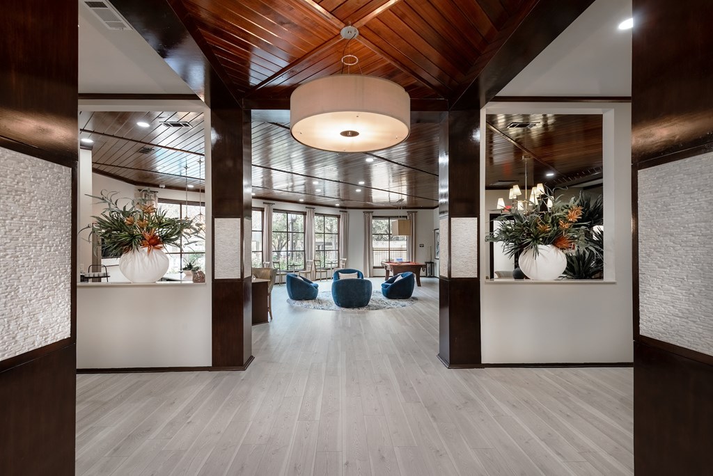 the lobby of a building with chairs and vases
