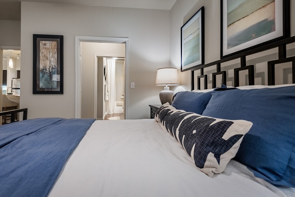 a bedroom with a large bed with blue and white sheets
