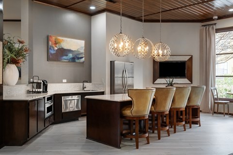 a kitchen with a long island with chairs and a sink