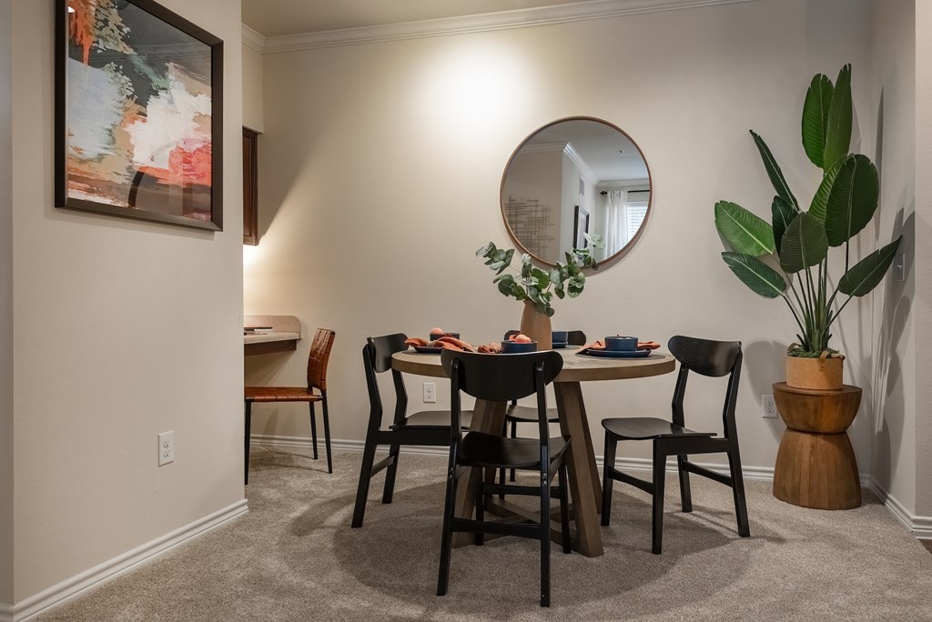 a dining room with a table and chairs and a mirror