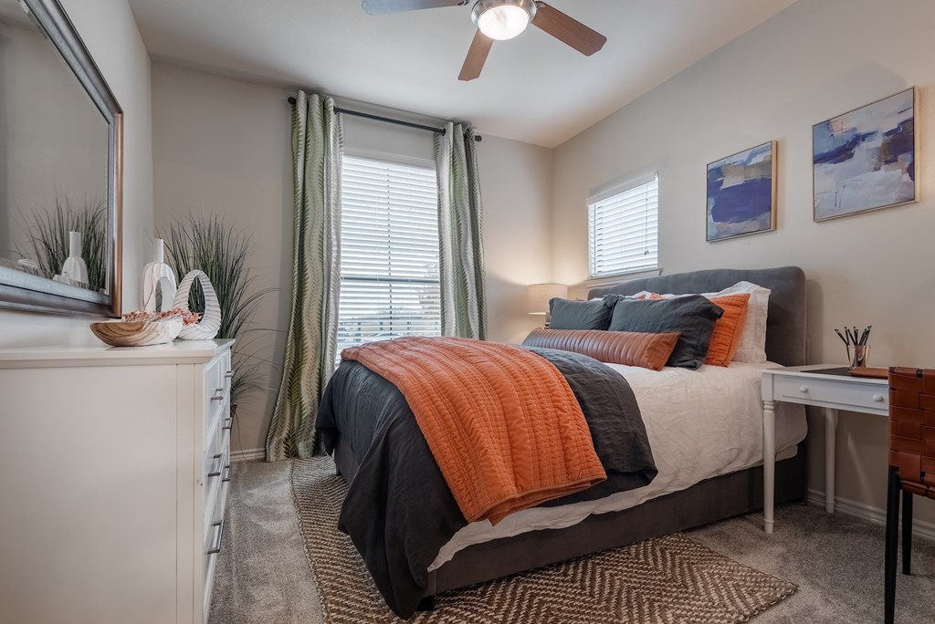 an open bedroom with a bed and a ceiling fan