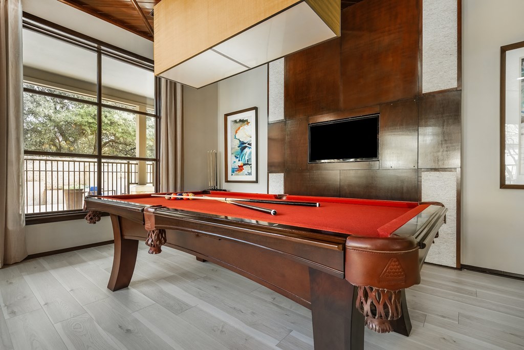 a games room with a pool table and a television
