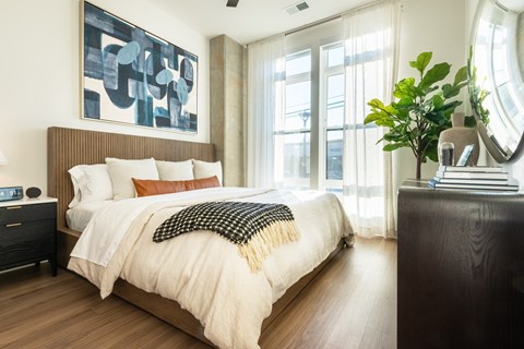 A bedroom with a large bed and a painting on the wall.