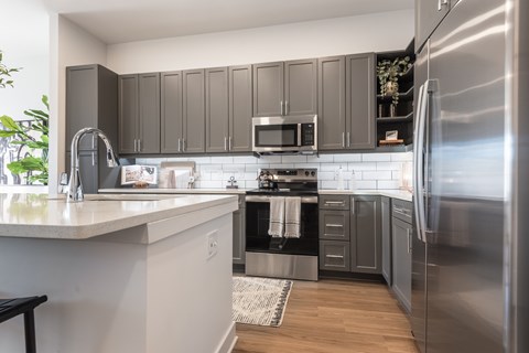 A modern kitchen with a stainless steel refrigerator and a white countertop.