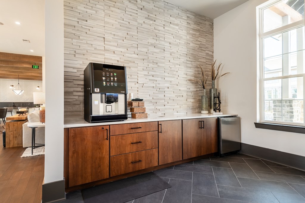 a kitchen with a coffee maker on a counter and a brick wall