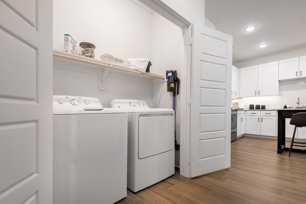 a washer and dryer in a laundry room with white cabinets