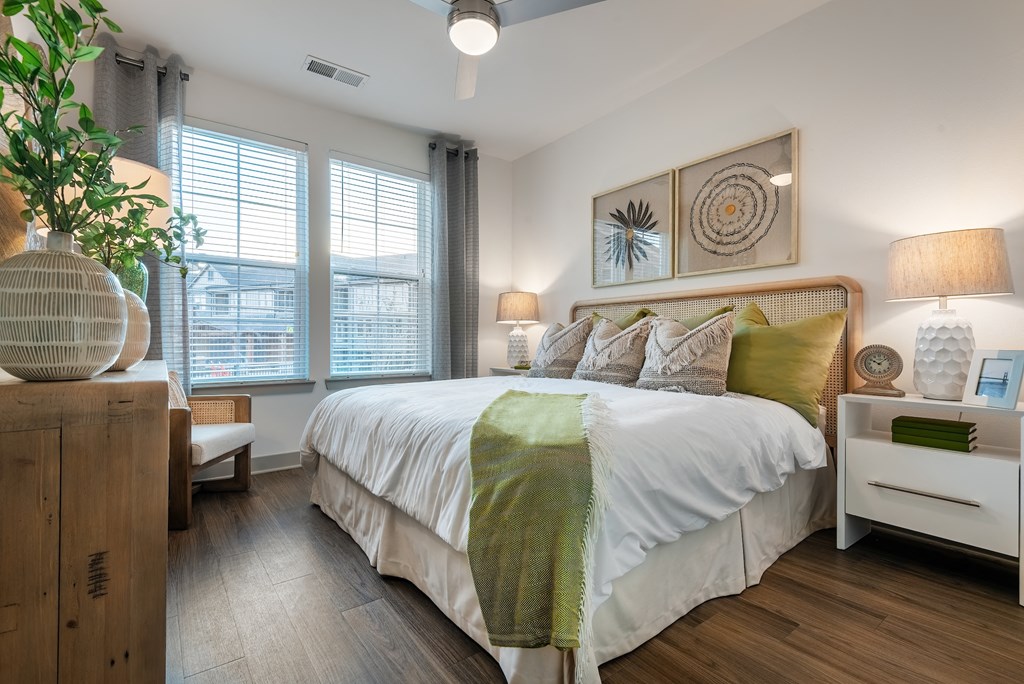 a bedroom with a large bed and two windows