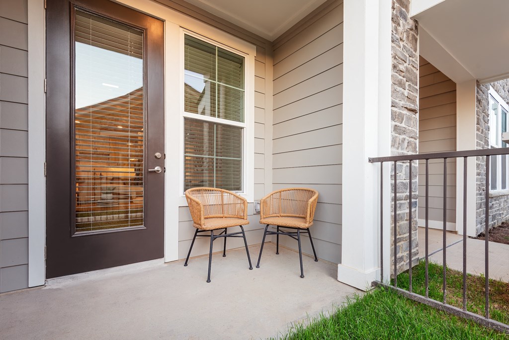 two chairs sitting on a porch in front of a door