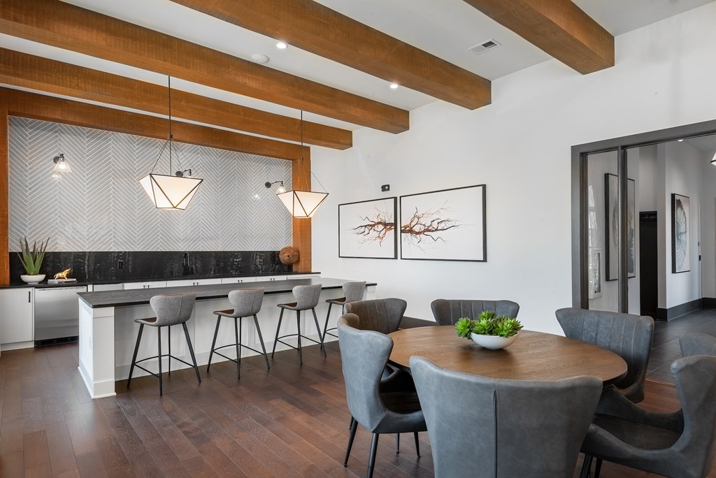 a dining area with a wooden table and chairs and a kitchen with a bar