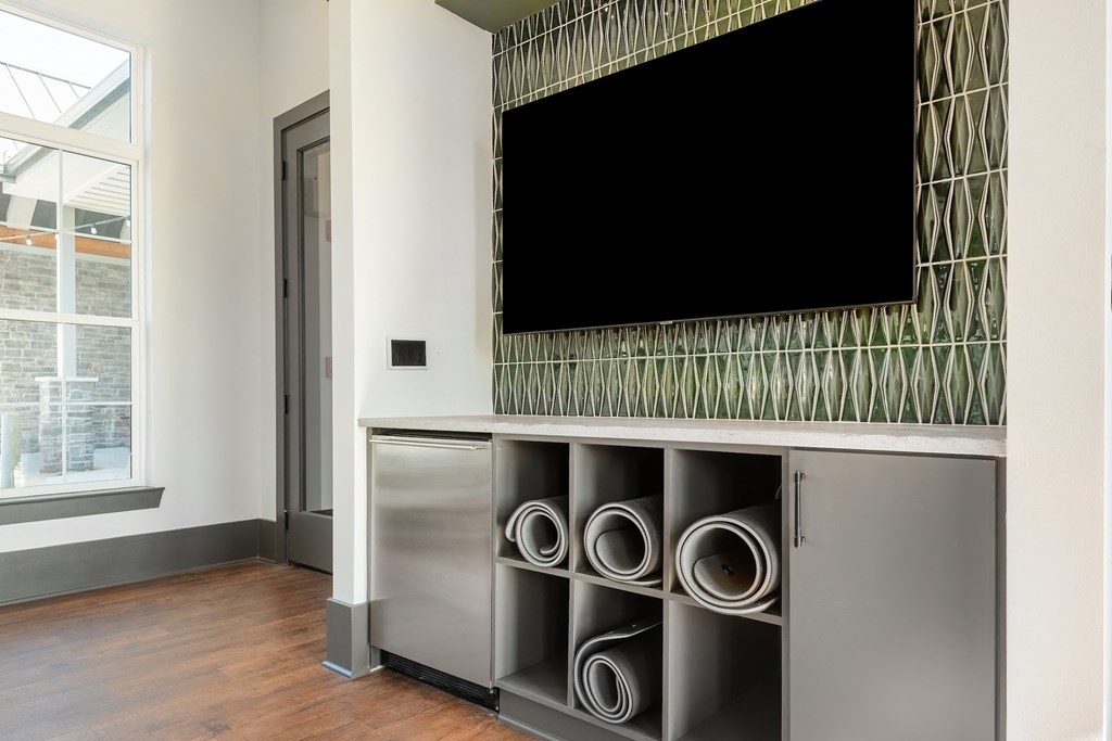 a living room with a tv on the wall and a stainless steel entertainment center