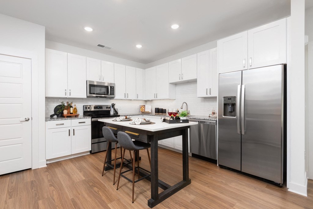 a white kitchen with stainless steel appliances and a counter top