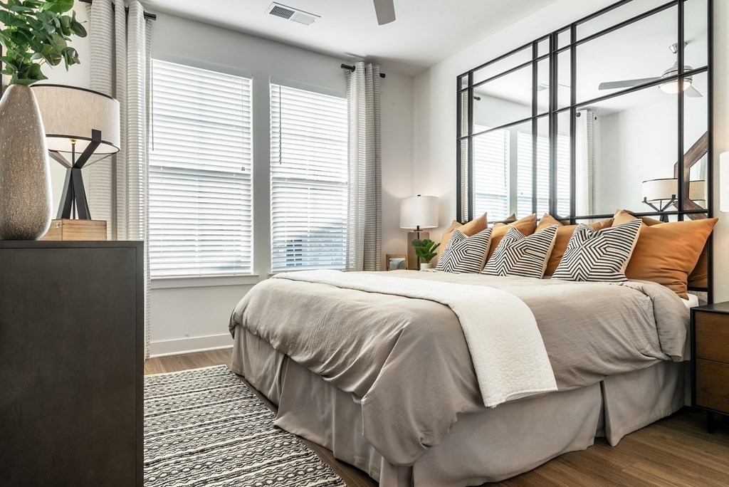 a bedroom with a large bed and three windows