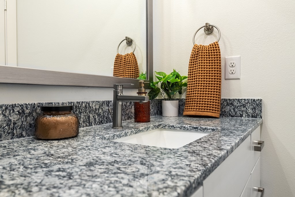 a kitchen counter with a sink and a mirror