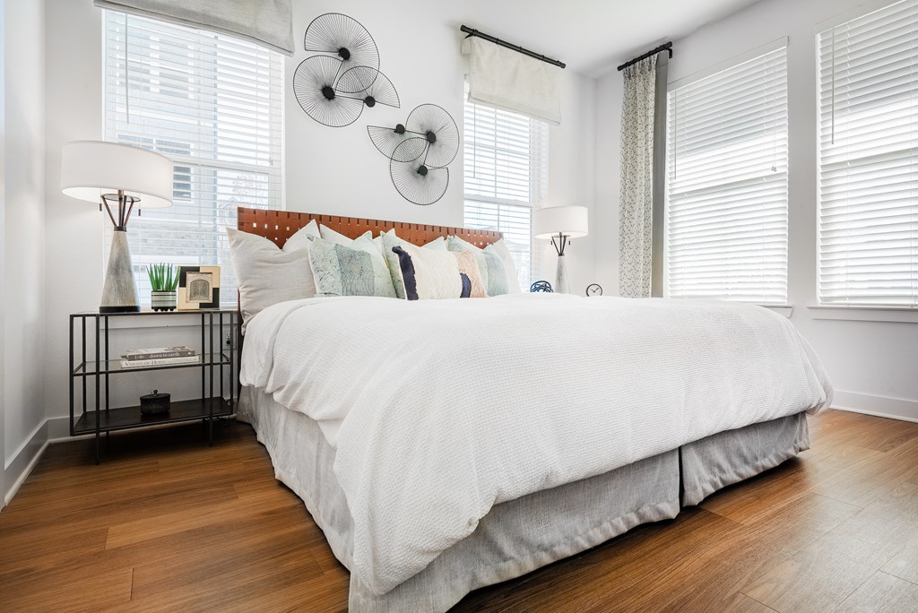 a bedroom with a bed and three windows