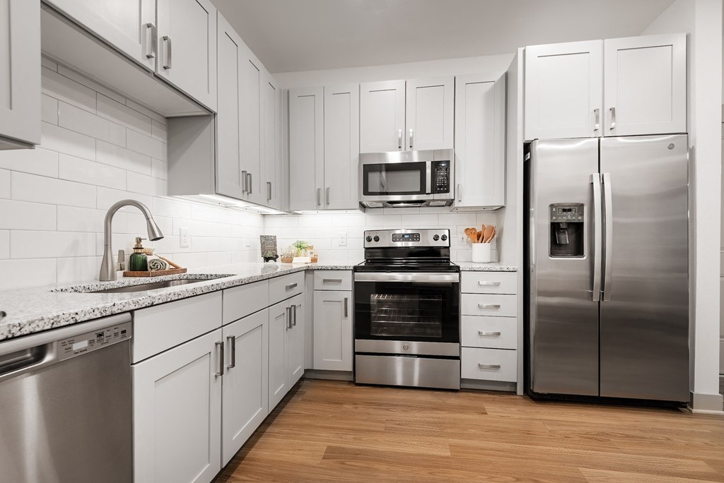 a kitchen with white cabinets and stainless steel appliances